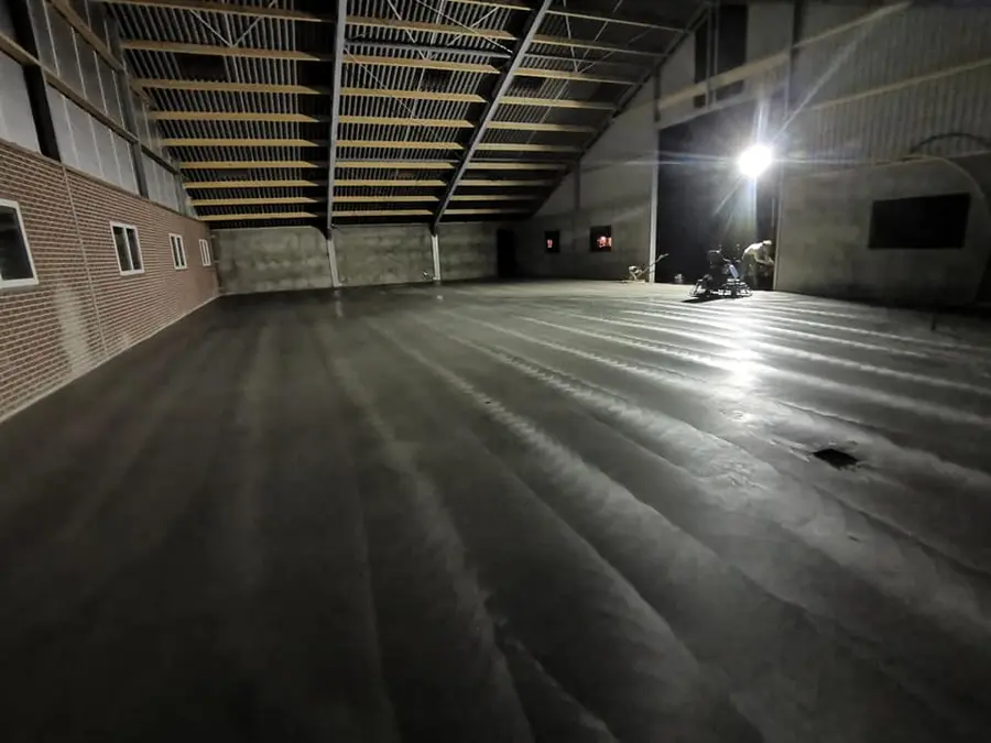 Monoliet afwerken en machinaal vlinderen van betonvloer door Meuleman Betonvloeren
